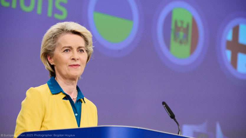 Ursula von der Leyen addressing audience with Georgia, Moldova and Ukraine flags in the background.