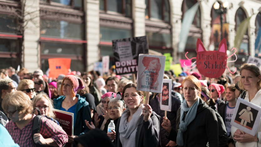 group of women marching in a crowd.